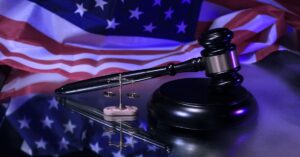 Gavel and scales of justice in front of American flag representing Wenatchee immigration green card law in Washington