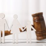 Paper cutout of a family next to a judge gavel